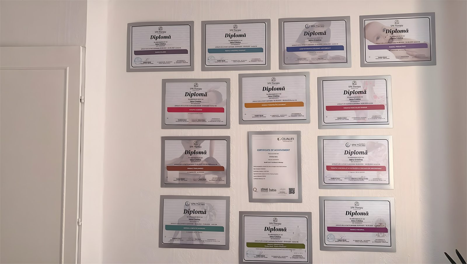 Framed massage qualification certificates on the wall